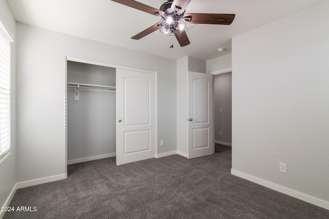 unfurnished bedroom featuring a closet, multiple windows, ceiling fan, and dark carpet