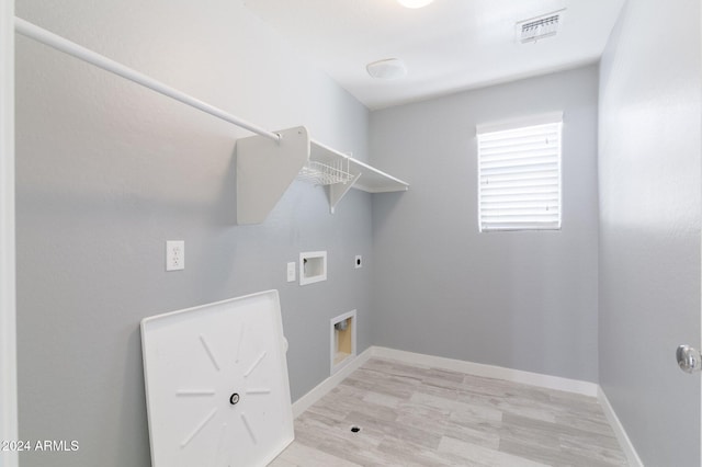 washroom featuring hookup for a washing machine, light hardwood / wood-style floors, and hookup for an electric dryer