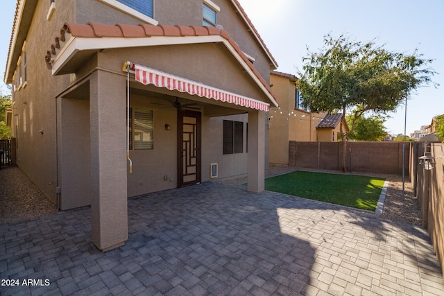 back of property featuring ceiling fan and a patio