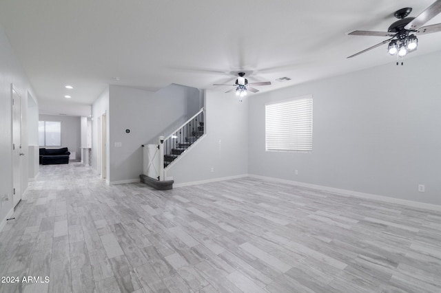 unfurnished living room with light wood-type flooring, plenty of natural light, and ceiling fan