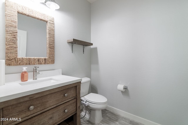 bathroom featuring toilet, vanity, and wood-type flooring