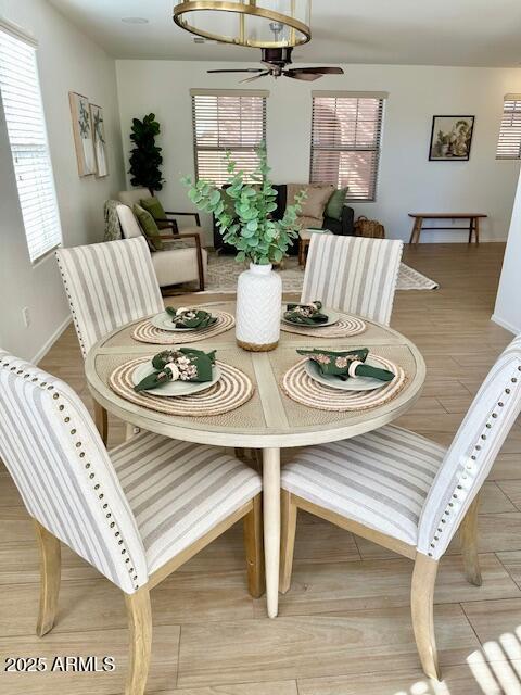 dining area with ceiling fan and light wood-type flooring