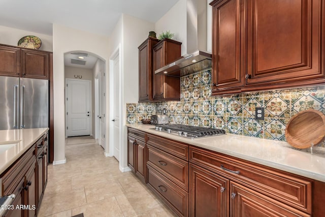 4149 N Brigadier Dr, Florence, AZ 85132 - kitchen featuring arched walkways, light countertops, wall chimney range hood, and stainless steel appliances