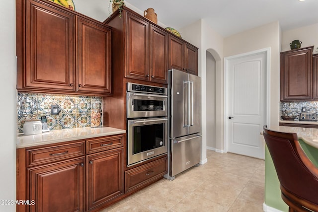 4149 N Brigadier Dr, Florence, AZ 85132 - kitchen featuring arched walkways, light countertops, appliances with stainless steel finishes, and tasteful backsplash