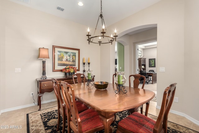 4149 N Brigadier Dr, Florence, AZ 85132 - dining area featuring a chandelier, arched walkways, light tile patterned flooring, visible vents, and baseboards