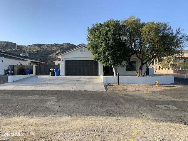 2701 E Caldwell St, Phoenix, AZ 85042 - view of front facade featuring fence, a mountain view, concrete driveway, an attached garage, and stucco siding