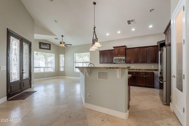 2701 E Caldwell St, Phoenix, AZ 85042 - kitchen featuring appliances with stainless steel finishes, a breakfast bar area, recessed lighting, lofted ceiling, and visible vents