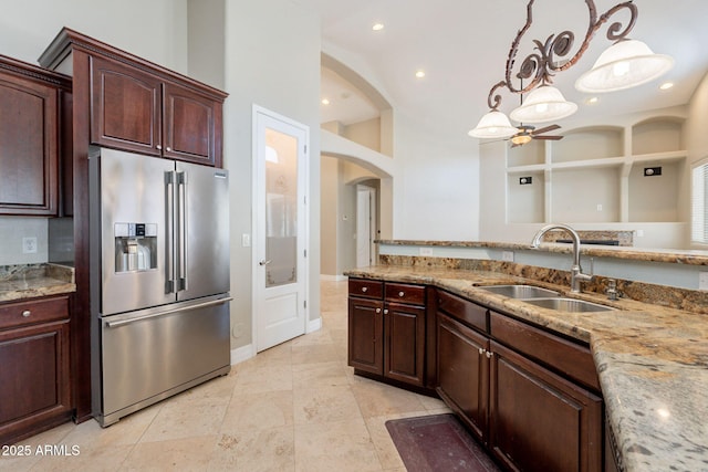 2701 E Caldwell St, Phoenix, AZ 85042 - kitchen with light stone countertops, hanging light fixtures, a sink, stainless steel fridge with ice dispenser, and arched walkways