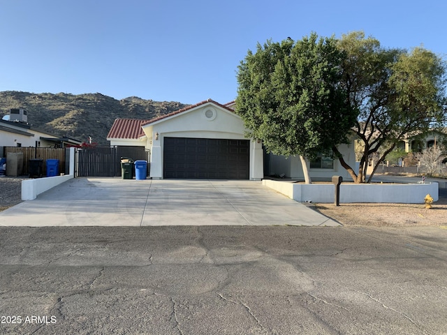 2701 E Caldwell St, Phoenix, AZ 85042 - view of front facade with fence, a gate, an attached garage, a mountain view, and driveway