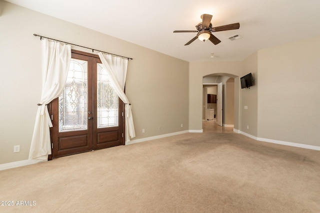 2701 E Caldwell St, Phoenix, AZ 85042 - unfurnished room featuring ceiling fan, carpet floors, arched walkways, baseboards, and visible vents