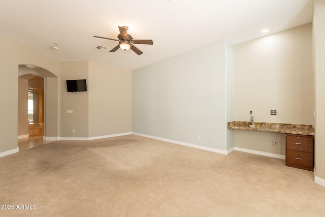 2701 E Caldwell St, Phoenix, AZ 85042 - unfurnished living room with light colored carpet, arched walkways, ceiling fan, and visible vents