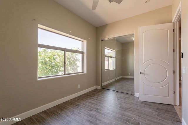 2701 E Caldwell St, Phoenix, AZ 85042 - unfurnished bedroom with a ceiling fan, baseboards, wood finished floors, and a closet