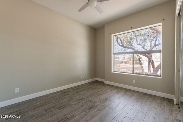 2701 E Caldwell St, Phoenix, AZ 85042 - empty room featuring baseboards, plenty of natural light, a ceiling fan, and dark wood-style flooring