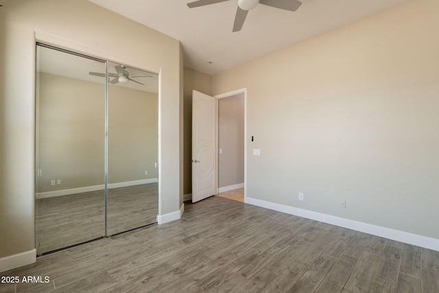 2701 E Caldwell St, Phoenix, AZ 85042 - unfurnished bedroom featuring baseboards, ceiling fan, a closet, and wood finished floors