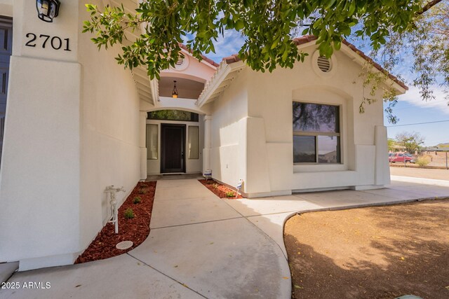 2701 E Caldwell St, Phoenix, AZ 85042 - view of exterior entry with stucco siding and a tiled roof
