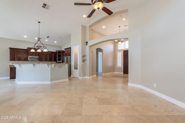 2701 E Caldwell St, Phoenix, AZ 85042 - unfurnished living room featuring arched walkways, high vaulted ceiling, ceiling fan with notable chandelier, recessed lighting, and visible vents