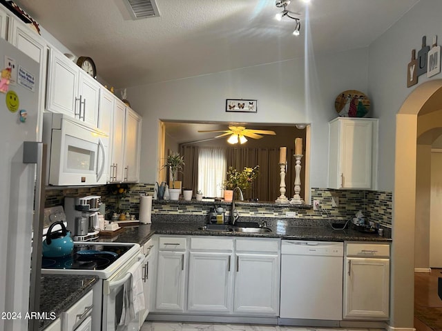 kitchen featuring white appliances, vaulted ceiling, sink, and white cabinets