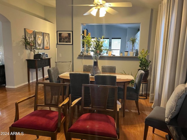 dining space with ceiling fan, vaulted ceiling, and wood-type flooring