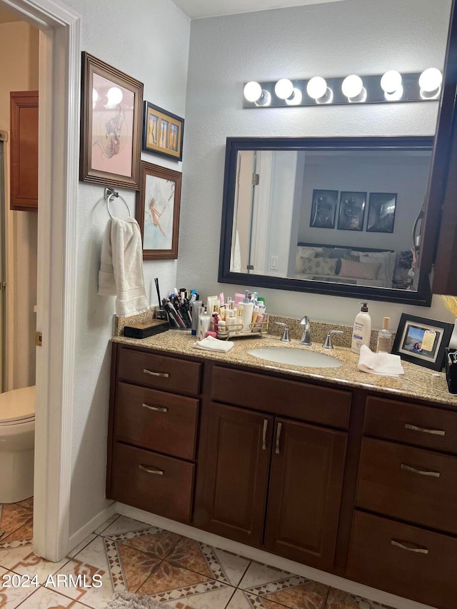 bathroom with tile patterned flooring, vanity, and toilet