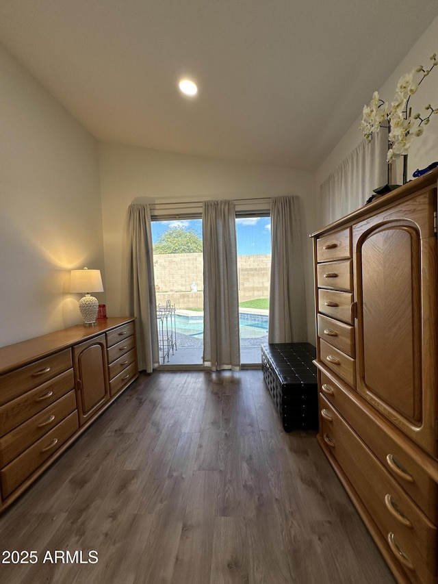 unfurnished bedroom with access to outside, vaulted ceiling, and dark wood finished floors