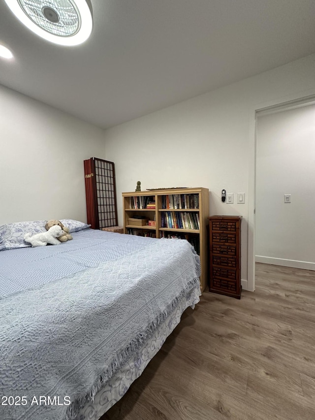 bedroom with baseboards and wood finished floors