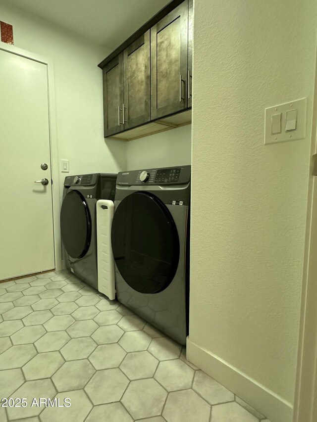 laundry area featuring baseboards, cabinet space, and washer and dryer