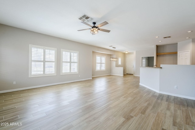 6317 S Kimberlee Way, Chandler, AZ 85249 - unfurnished living room featuring a ceiling fan, light wood-style floors, recessed lighting, baseboards, and a chandelier