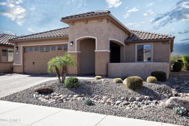 26421 W Zachary Dr, Buckeye, AZ 85396 - mediterranean / spanish-style home featuring a garage, driveway, a tiled roof, and stucco siding