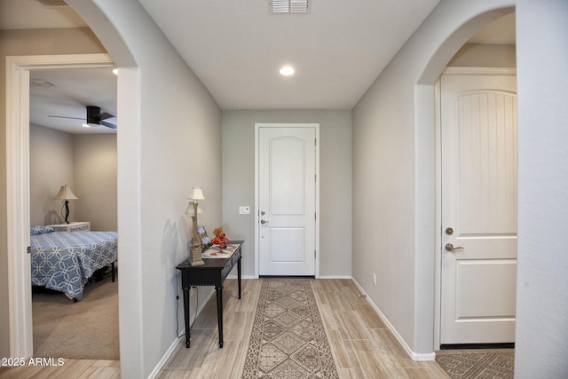 26421 W Zachary Dr, Buckeye, AZ 85396 - corridor with visible vents, baseboards, arched walkways, light wood-style floors, and recessed lighting