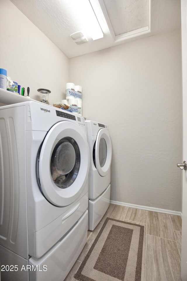 26421 W Zachary Dr, Buckeye, AZ 85396 - clothes washing area featuring baseboards, light wood finished floors, washer and dryer, and laundry area