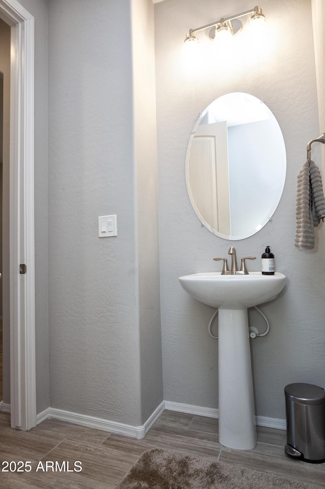 26421 W Zachary Dr, Buckeye, AZ 85396 - bathroom featuring baseboards, a sink, and wood finished floors