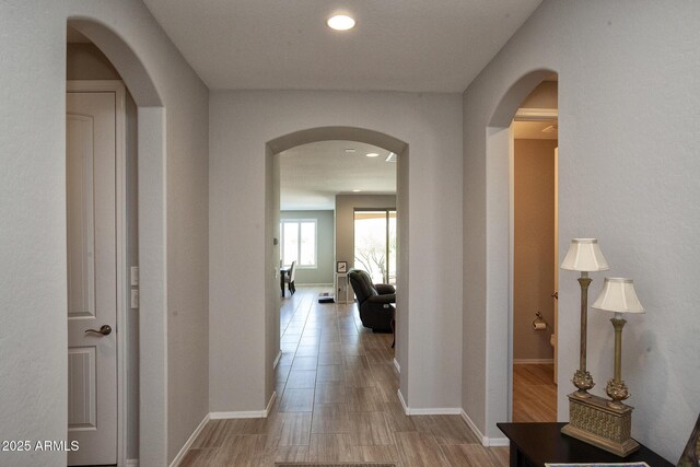 26421 W Zachary Dr, Buckeye, AZ 85396 - corridor featuring arched walkways, recessed lighting, baseboards, and wood finished floors
