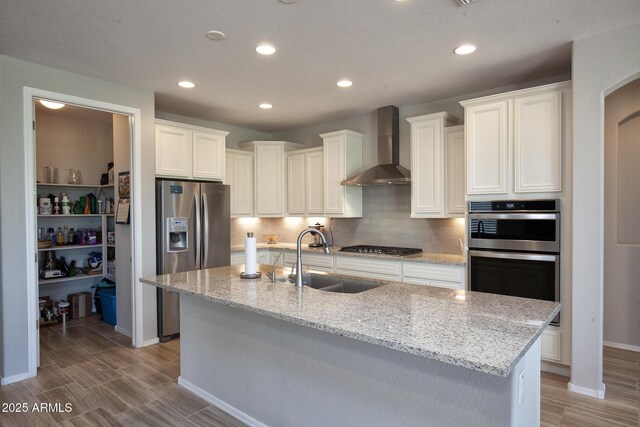 26421 W Zachary Dr, Buckeye, AZ 85396 - kitchen featuring tasteful backsplash, wall chimney exhaust hood, a sink, recessed lighting, and stainless steel appliances
