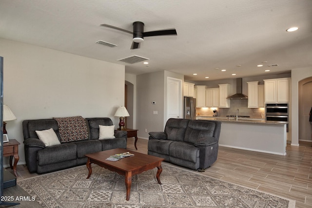 26421 W Zachary Dr, Buckeye, AZ 85396 - living area with recessed lighting, light wood-style flooring, visible vents, ceiling fan, and arched walkways