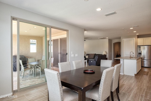 26421 W Zachary Dr, Buckeye, AZ 85396 - dining room with wood tiled floor, arched walkways, visible vents, and recessed lighting