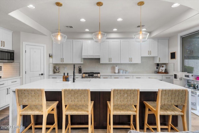2466 E Harrison Ct, Gilbert, AZ 85295 - kitchen featuring stainless steel appliances, backsplash, a sink, light countertops, and white cabinetry