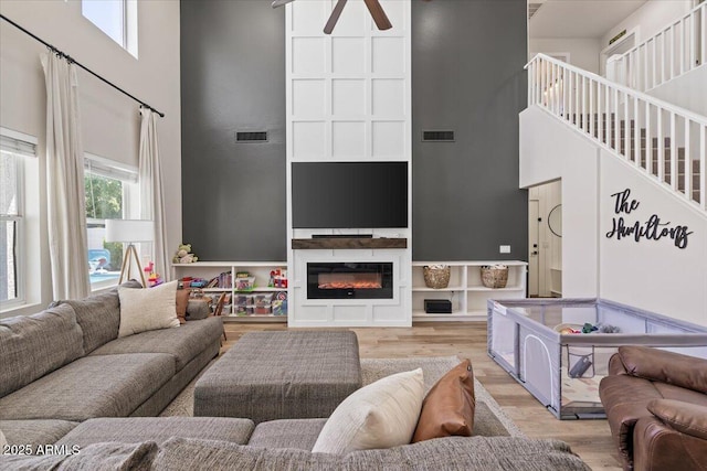 2466 E Harrison Ct, Gilbert, AZ 85295 - living area featuring a high ceiling, wood finished floors, ceiling fan, and a glass covered fireplace