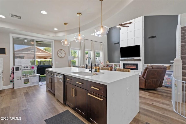 2466 E Harrison Ct, Gilbert, AZ 85295 - kitchen featuring a sink, stainless steel dishwasher, light wood-style flooring, ceiling fan, and a large fireplace