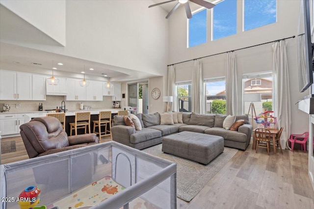 2466 E Harrison Ct, Gilbert, AZ 85295 - living room featuring light wood-style floors, a towering ceiling, and a ceiling fan