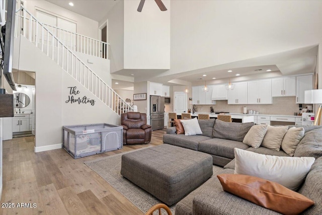 2466 E Harrison Ct, Gilbert, AZ 85295 - living area with stairway, a high ceiling, light wood-style flooring, ceiling fan, and recessed lighting
