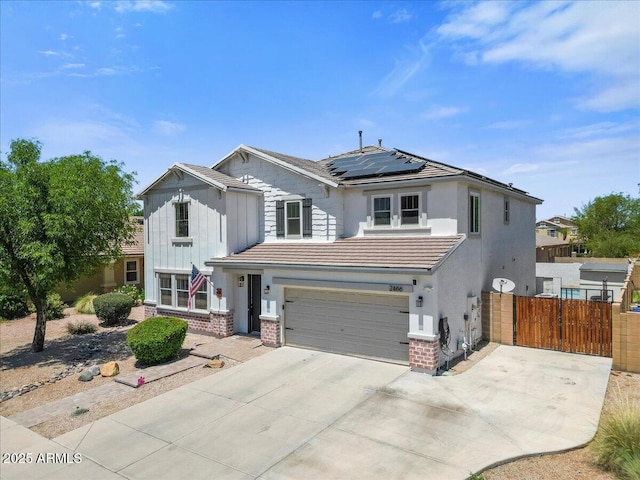 2466 E Harrison Ct, Gilbert, AZ 85295 - view of front of home with roof mounted solar panels, brick siding, driveway, and a garage