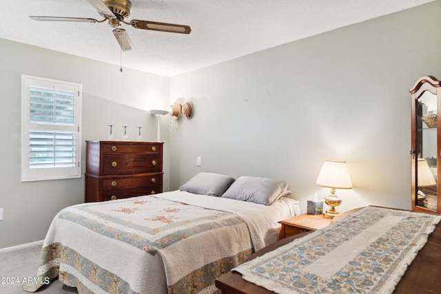 bedroom with ceiling fan and a textured ceiling