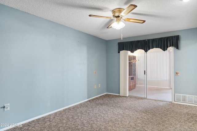 unfurnished bedroom with ceiling fan, carpet floors, and a textured ceiling