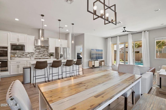 dining space with visible vents, recessed lighting, a ceiling fan, and light wood-style floors