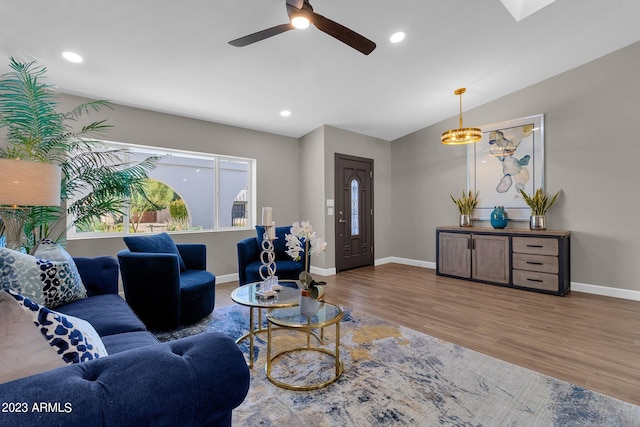 living room with wood-type flooring, ceiling fan, and vaulted ceiling