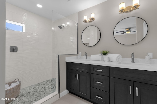 bathroom featuring tile patterned flooring, vanity, ceiling fan, and a tile shower