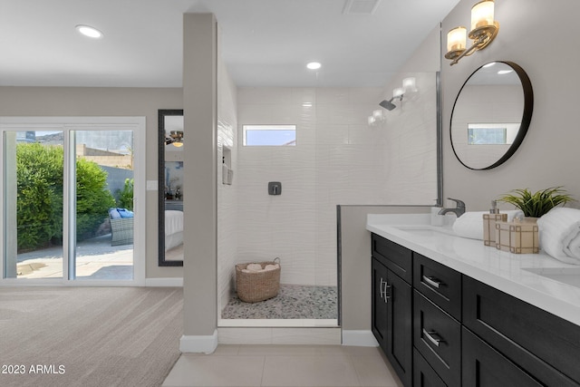 bathroom with vanity, a wealth of natural light, tile patterned floors, and tiled shower