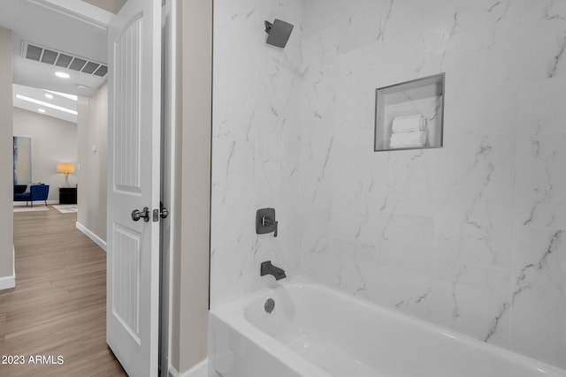 bathroom with wood-type flooring and tiled shower / bath