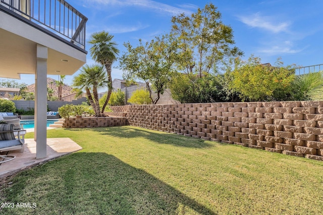 view of yard featuring a fenced in pool, a patio area, and a balcony