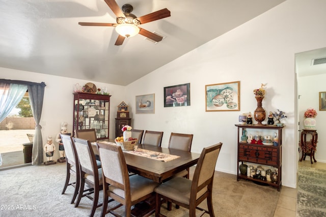 dining room with visible vents, a ceiling fan, vaulted ceiling, and light colored carpet